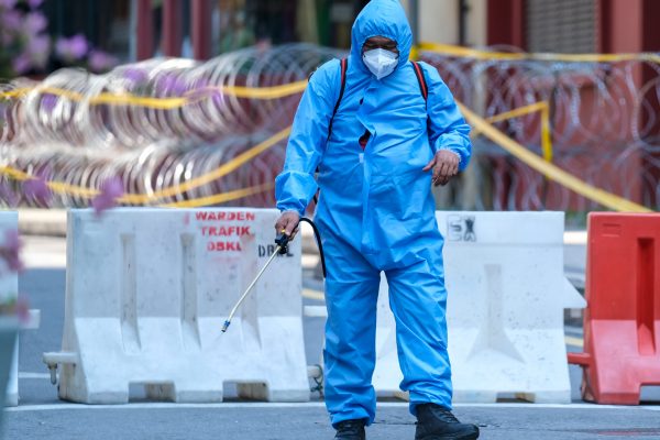 KUALA LUMPUR, MALAYSIA - APRIL 19, 2020: Police personnel from health department sanitizing lockdown area to prevent the spread of the Coronavirus disease 2019 (COVID-19) outbreak.