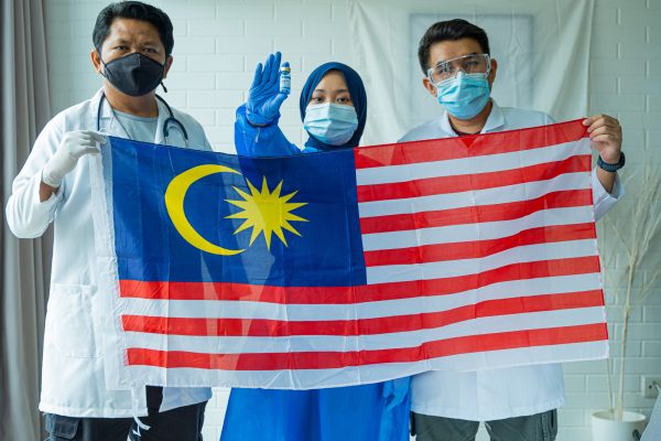 Frontliner concept, Malaysian people wearing medical suit holding Flag